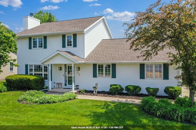 2592 Radinz Rd, Green Bay, WI 54311 - view of front of house with a chimney, a front lawn, and roof with shingles