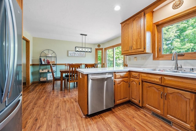 2592 Radinz Rd, Green Bay, WI 54311 - kitchen featuring appliances with stainless steel finishes, a sink, light wood-style floors, brown cabinetry, and recessed lighting