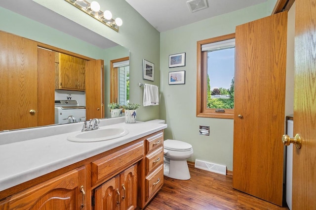 2592 Radinz Rd, Green Bay, WI 54311 - bathroom featuring washer / dryer, toilet, vanity, wood finished floors, and baseboards