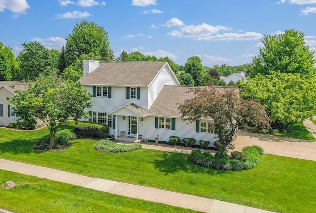 2592 Radinz Rd, Green Bay, WI 54311 - view of front of property with a front lawn, roof with shingles, concrete driveway, and a chimney