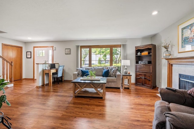 2592 Radinz Rd, Green Bay, WI 54311 - living room featuring wood finished floors, plenty of natural light, a tiled fireplace, recessed lighting, and stairs