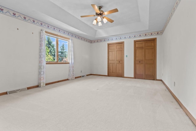146 Old Orchard Ln, Neenah, WI 54956 - empty room with a ceiling fan, light carpet, a tray ceiling, and baseboards