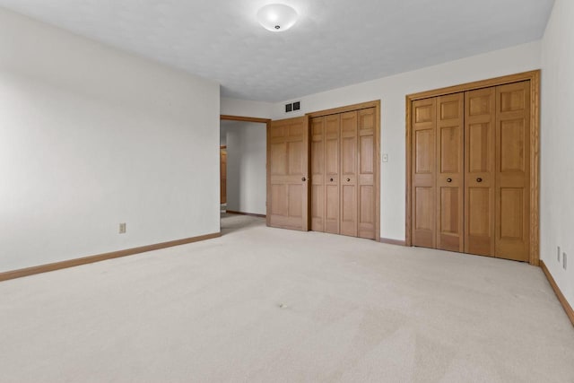 146 Old Orchard Ln, Neenah, WI 54956 - unfurnished bedroom featuring two closets, carpet flooring, and baseboards