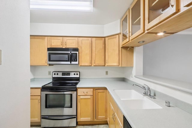 809 Harbor House Dr Unit 4, Madison, WI 53719 - kitchen featuring stainless steel appliances, a sink, light countertops, glass insert cabinets, and light brown cabinets