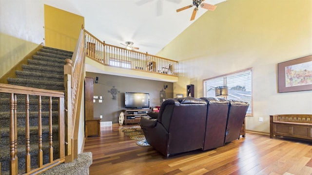 N6464 Canterbury Dr, Fond Du Lac, WI 54937 - living area featuring ceiling fan, stairway, wood finished floors, a high ceiling, and baseboards