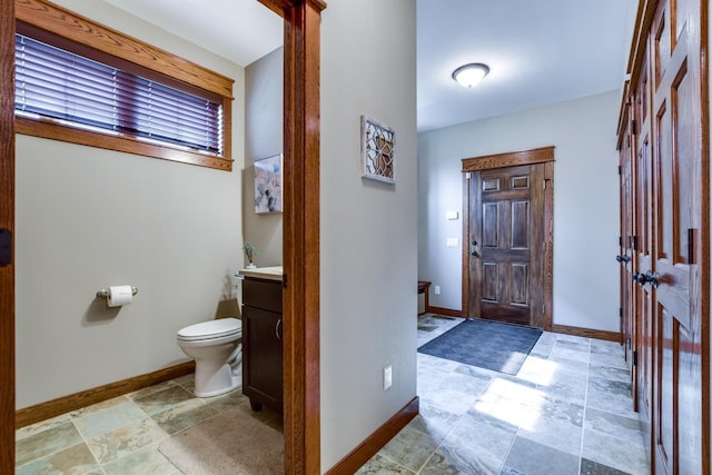 392 Campbell Hill Ct, Deforest, WI 53532 - bathroom with vanity, baseboards, toilet, and stone finish flooring