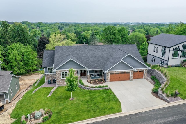 392 Campbell Hill Ct, Deforest, WI 53532 - craftsman-style home with stone siding, an attached garage, driveway, a front lawn, and a porch