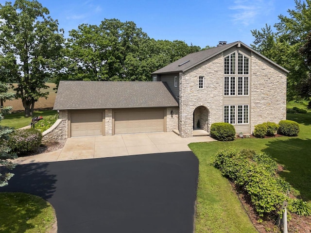 3544 Windsong Ter, Oshkosh, WI 54904 - view of front of home with stone siding, a garage, a front yard, and driveway