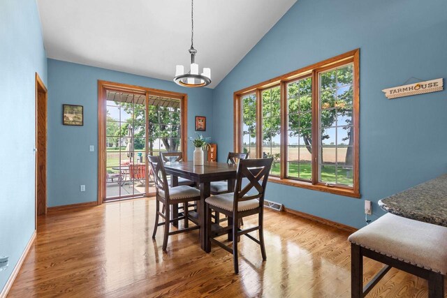 3544 Windsong Ter, Oshkosh, WI 54904 - dining room featuring lofted ceiling, a chandelier, wood finished floors, and baseboards