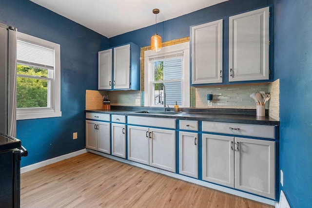 1212 N Leminwah St, Appleton, WI 54911 - kitchen featuring a sink, dark countertops, backsplash, and light wood-type flooring