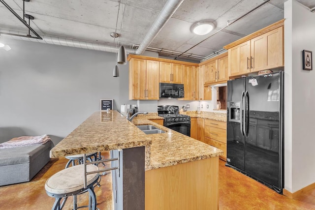 102 N Water St Unit 411, Milwaukee, WI 53202 - kitchen with black appliances, a peninsula, light brown cabinetry, a breakfast bar, and concrete flooring