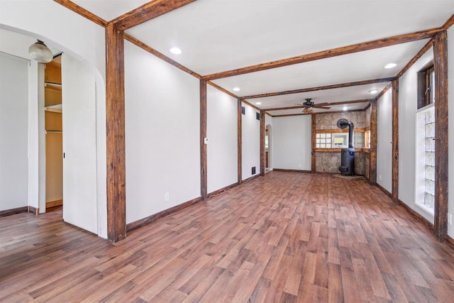 N7618 County Road C, Eldorado, WI 54932 - unfurnished living room with healthy amount of natural light, wood finished floors, a wood stove, beamed ceiling, and crown molding