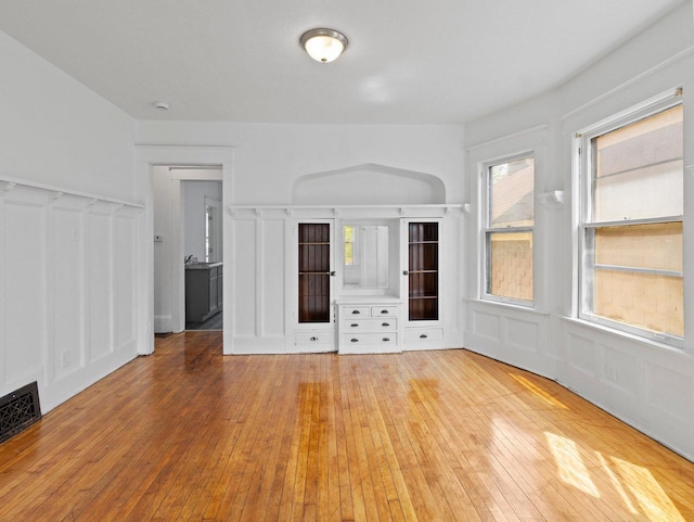 2544 N 35th St Unit 2546, Milwaukee, WI 53210 - unfurnished living room featuring a decorative wall, wood-type flooring, and a wainscoted wall