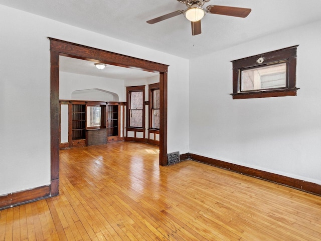 2544 N 35th St Unit 2546, Milwaukee, WI 53210 - spare room featuring baseboards, hardwood / wood-style floors, a ceiling fan, and arched walkways