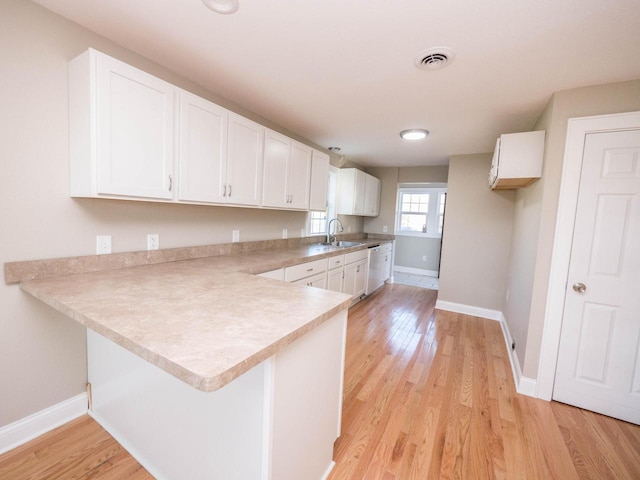8428 Fox River Rd, Waterford, WI 53185 - kitchen featuring a sink, white cabinets, dishwasher, a peninsula, and baseboards