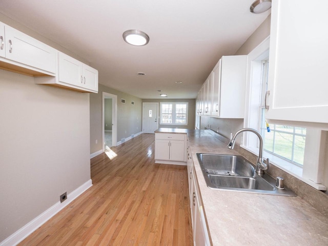 8428 Fox River Rd, Waterford, WI 53185 - kitchen featuring a sink, white cabinets, baseboards, and light wood-style flooring