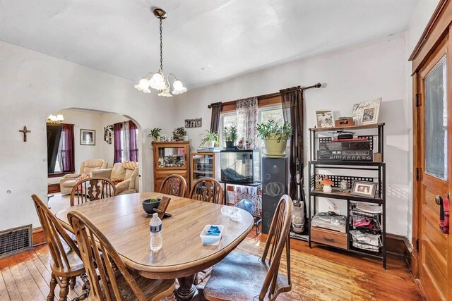 823 N Main St, Marion, WI 54950 - dining space featuring arched walkways, hardwood / wood-style flooring, and a chandelier