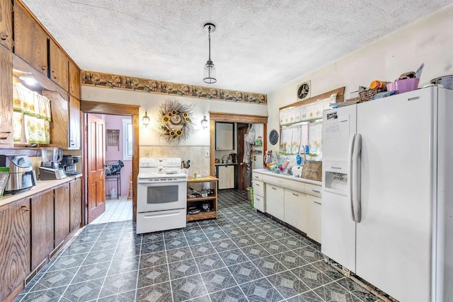 823 N Main St, Marion, WI 54950 - kitchen with white appliances, light countertops, brown cabinetry, a textured ceiling, and decorative light fixtures