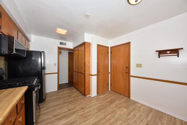 3825 S 5th St Unit 3823, Milwaukee, WI 53207 - kitchen featuring stainless steel appliances, brown cabinets, light wood-style floors, and baseboards