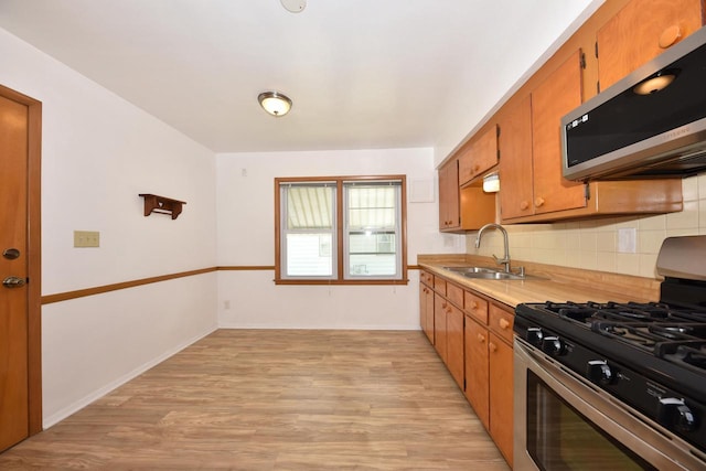 3825 S 5th St Unit 3823, Milwaukee, WI 53207 - kitchen with stainless steel appliances, a sink, light wood-style flooring, and tasteful backsplash