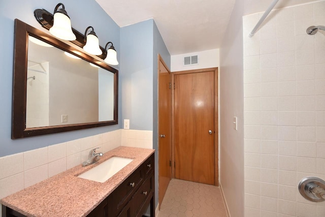 3825 S 5th St Unit 3823, Milwaukee, WI 53207 - bathroom featuring vanity, tiled shower, tasteful backsplash, and tile patterned floors