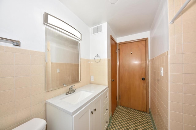 3825 S 5th St Unit 3823, Milwaukee, WI 53207 - bathroom with tile walls, vanity, wainscoting, toilet, and tile patterned floors