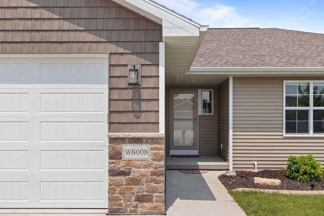 W6008 Zach St, Menasha, WI 54952 - view of exterior entry with a shingled roof and stone siding