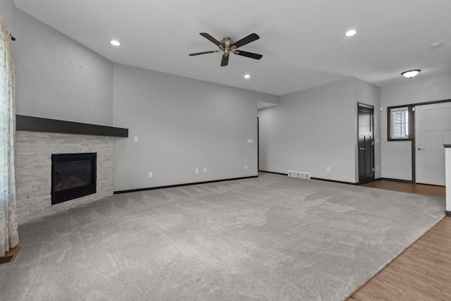 W6008 Zach St, Menasha, WI 54952 - unfurnished living room with a ceiling fan, a stone fireplace, baseboards, recessed lighting, and wood finished floors