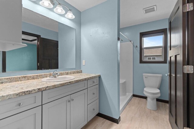 W6008 Zach St, Menasha, WI 54952 - full bathroom featuring toilet, vanity, a shower, and baseboards