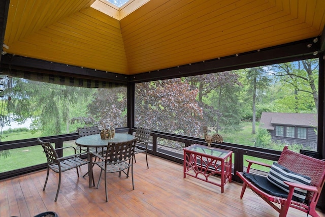 2937 N Mill Rd, Oconomowoc, WI 53066 - sunroom / solarium with a skylight, outdoor dining space, a deck, wood-type flooring, and plenty of natural light
