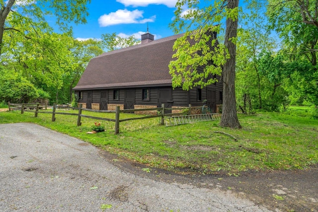 2937 N Mill Rd, Oconomowoc, WI 53066 - view of front facade featuring a barn, roof with shingles, a chimney, and an outdoor structure