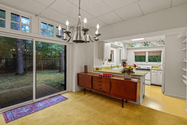 2937 N Mill Rd, Oconomowoc, WI 53066 - kitchen featuring electric stove, a drop ceiling, a sink, a chandelier, and white cabinets