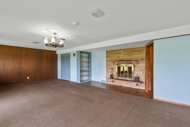2373 State Road 33, Saukville, WI 53080 - unfurnished living room featuring carpet flooring, wood walls, a chandelier, a large fireplace, and built in shelves