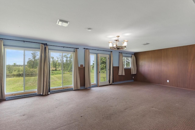 2373 State Road 33, Saukville, WI 53080 - carpeted empty room with a chandelier, wooden walls, and a smoke detector