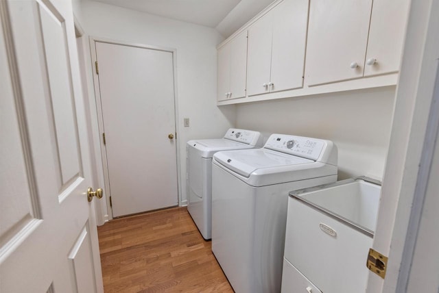 10109 N Gettysburg Ct, Mequon, WI 53092 - washroom featuring independent washer and dryer, cabinet space, and light wood-type flooring
