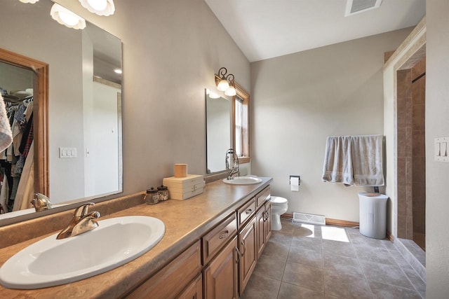 2527 W Crais Ct, De Pere, WI 54115 - bathroom featuring double vanity, tile patterned flooring, toilet, a tile shower, and a spacious closet