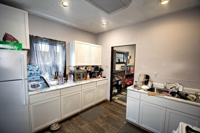 124 Allard Ave, Green Bay, WI 54303 - kitchen featuring freestanding refrigerator, light countertops, dark wood-style flooring, recessed lighting, and white cabinets