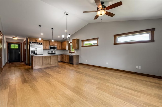2837 Patrick John Dr, Eau Claire, WI 54703 - kitchen featuring stainless steel appliances, light countertops, brown cabinetry, a sink, and lofted ceiling