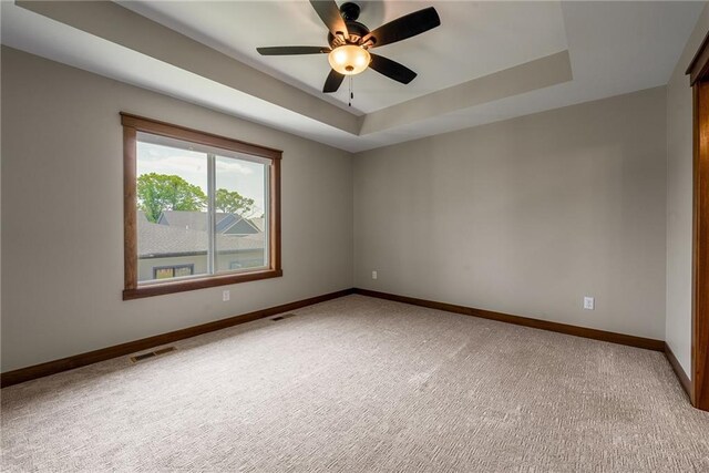 2837 Patrick John Dr, Eau Claire, WI 54703 - spare room featuring light carpet, a ceiling fan, baseboards, and a tray ceiling