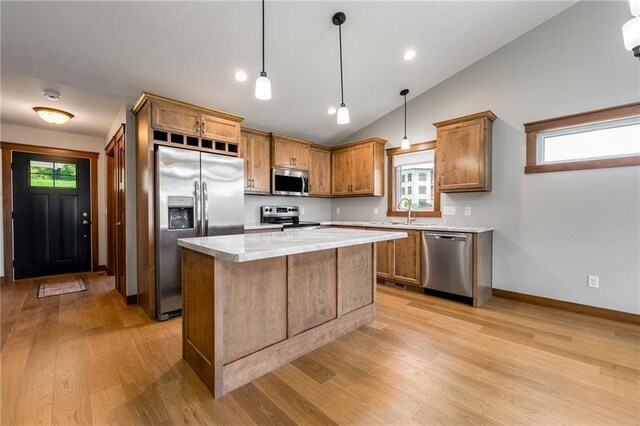 2837 Patrick John Dr, Eau Claire, WI 54703 - kitchen featuring appliances with stainless steel finishes, light wood-style flooring, light countertops, lofted ceiling, and a center island