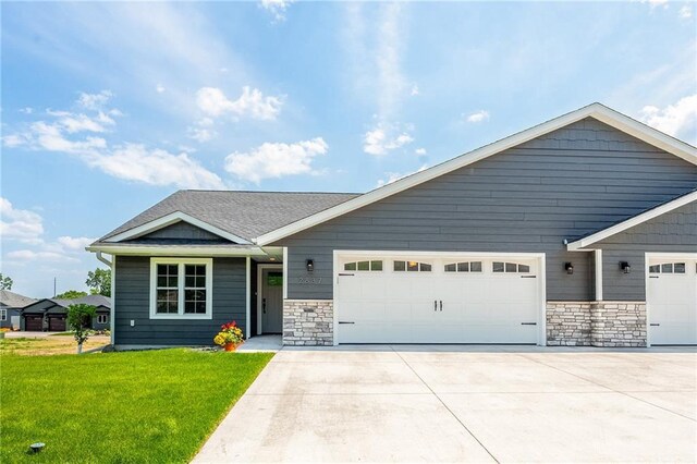 2837 Patrick John Dr, Eau Claire, WI 54703 - view of front facade featuring an attached garage, concrete driveway, a front yard, and stone siding