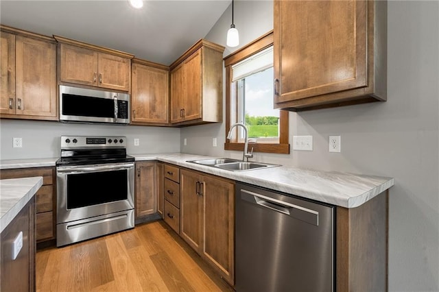 2837 Patrick John Dr, Eau Claire, WI 54703 - kitchen with appliances with stainless steel finishes, a sink, light wood-type flooring, light countertops, and brown cabinetry