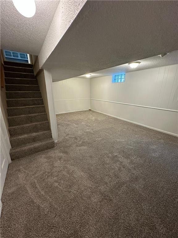 332 E Pleasant Ave, Ellsworth, WI 54011 - finished below grade area featuring a textured ceiling, stairs, and carpet floors