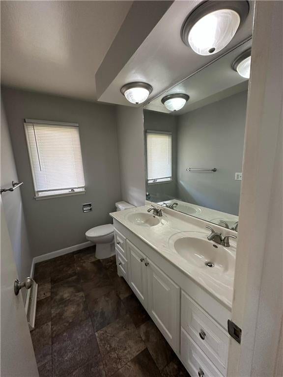 332 E Pleasant Ave, Ellsworth, WI 54011 - full bathroom featuring plenty of natural light, double vanity, toilet, and stone finish floors