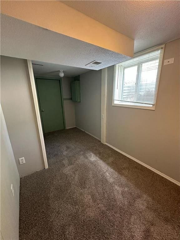 332 E Pleasant Ave, Ellsworth, WI 54011 - basement featuring a textured ceiling and dark colored carpet