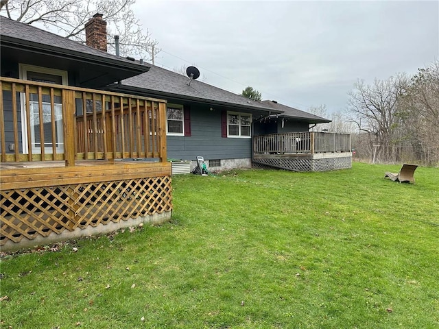 332 E Pleasant Ave, Ellsworth, WI 54011 - rear view of house featuring a wooden deck, roof with shingles, a yard, and a chimney