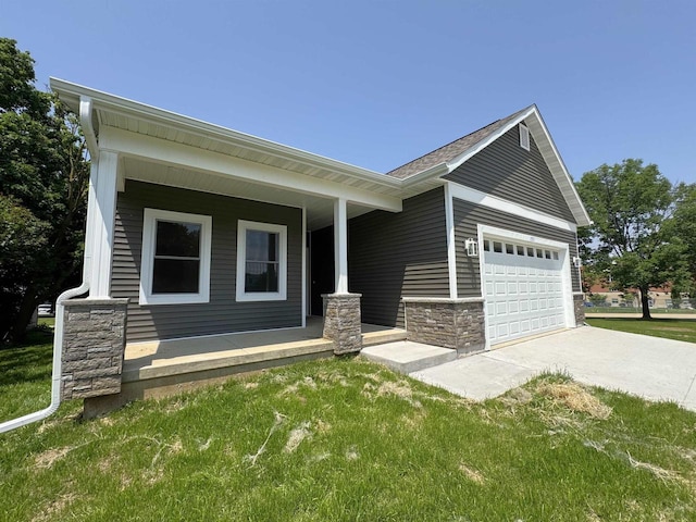 1511 16th Ave, Monroe, WI 53566 - view of front of property with a porch, stone siding, a garage, a front yard, and driveway