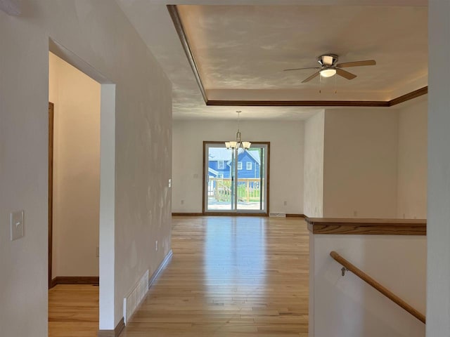 1511 16th Ave, Monroe, WI 53566 - spare room with a chandelier, light wood finished floors, a tray ceiling, ceiling fan, and baseboards