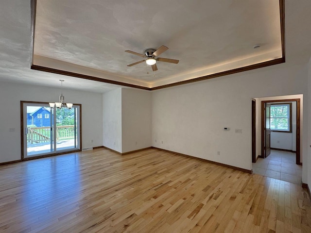 1511 16th Ave, Monroe, WI 53566 - empty room featuring a raised ceiling, a chandelier, and light wood-style floors