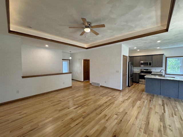 1511 16th Ave, Monroe, WI 53566 - unfurnished living room featuring a raised ceiling, ceiling fan, light wood finished floors, baseboards, and recessed lighting